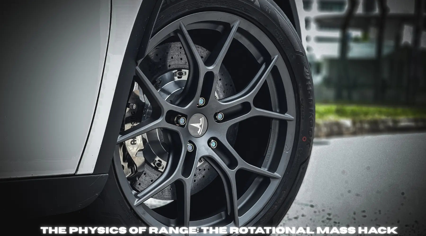 High-performance lightweight forged wheel on a modern electric vehicle in an engineering lab.