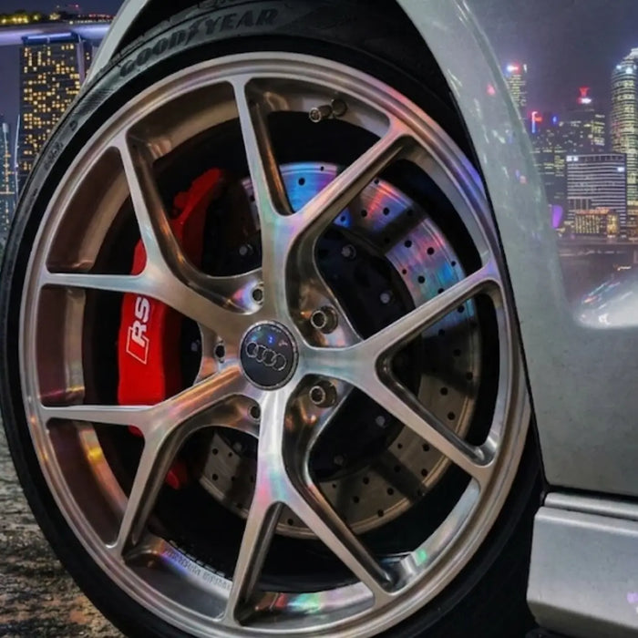 Custom 6061-T6 forged car rim and massive brake caliper on a dark sports car parked in Singapore at night.