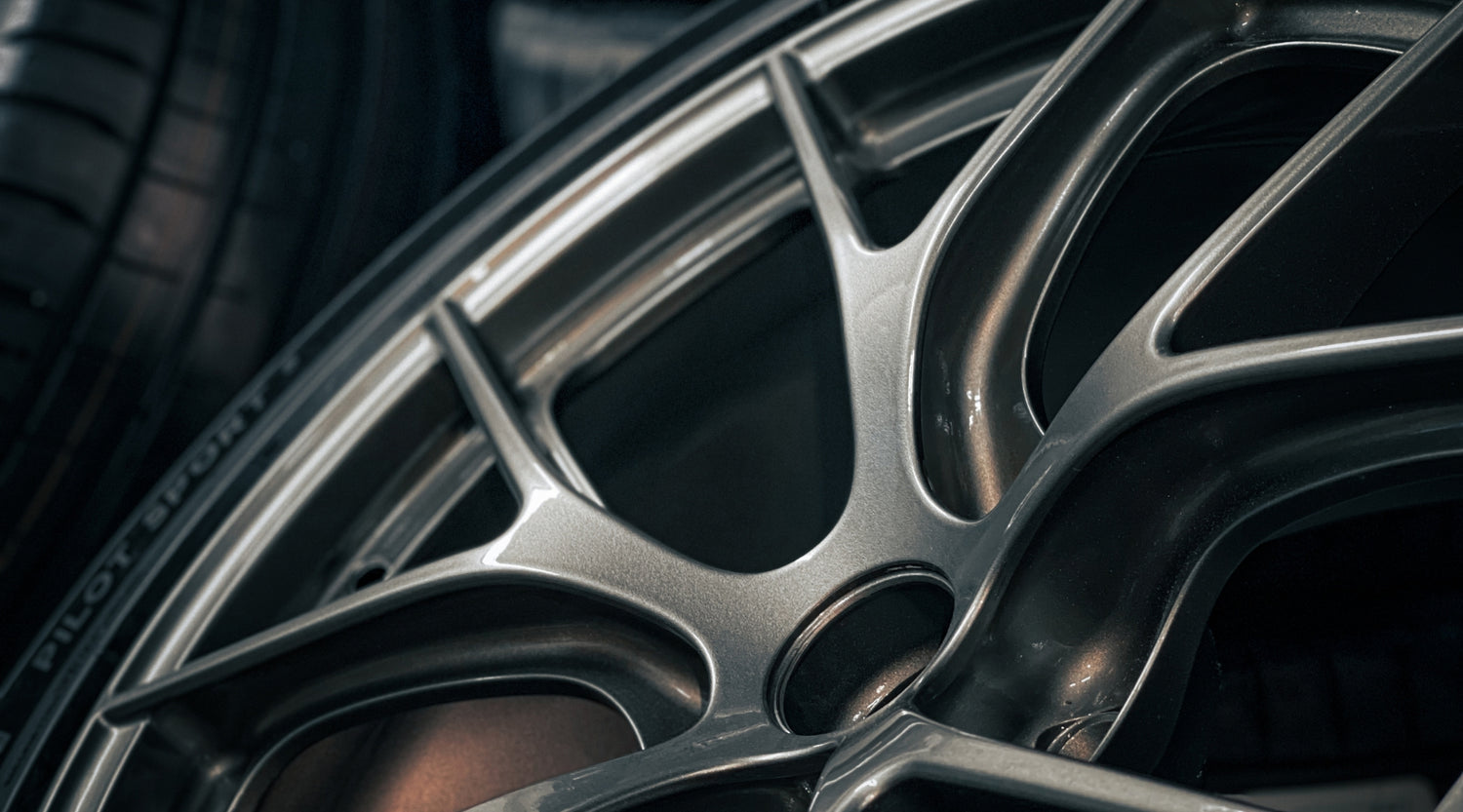 Close-up of a RRT charcoal grey multi-spoke alloy wheel mounted on a Michelin Pilot Sport tire.